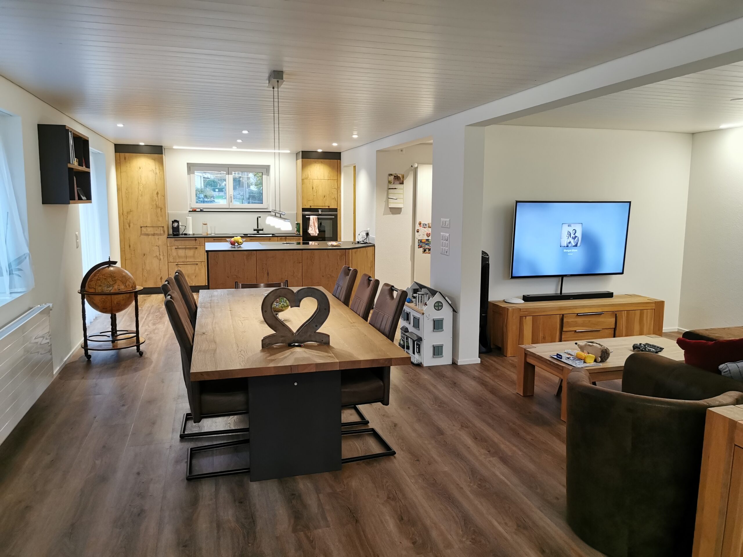 Wohnzimmer mit offener Küche in Holzoptik